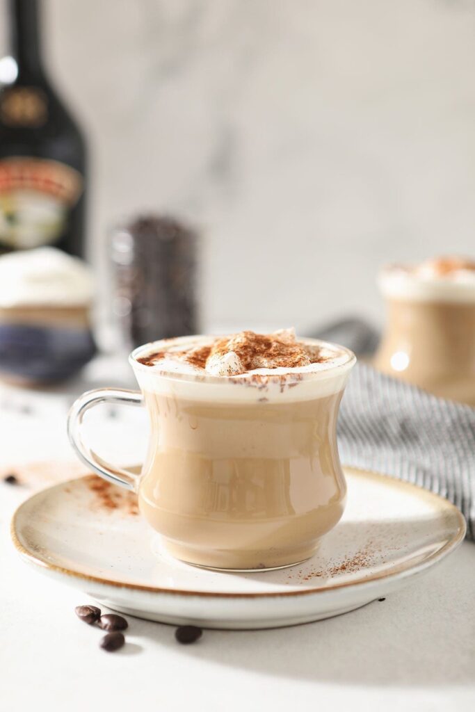 Close up of an Irish Cream Coffee topped with whipped cream on a plate