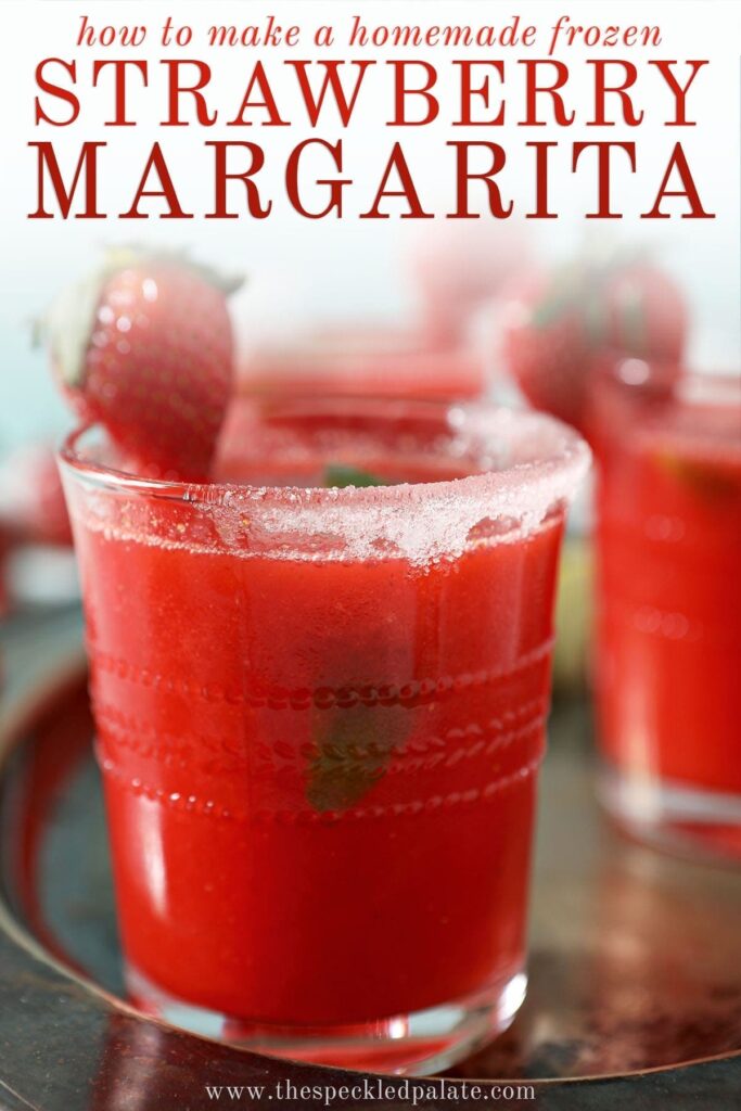 Close up of a strawberry margarita rimmed with sugar and garnished with a strawberry and a lime wedge with the text 'how to make a homemade frozen strawberry margarita'