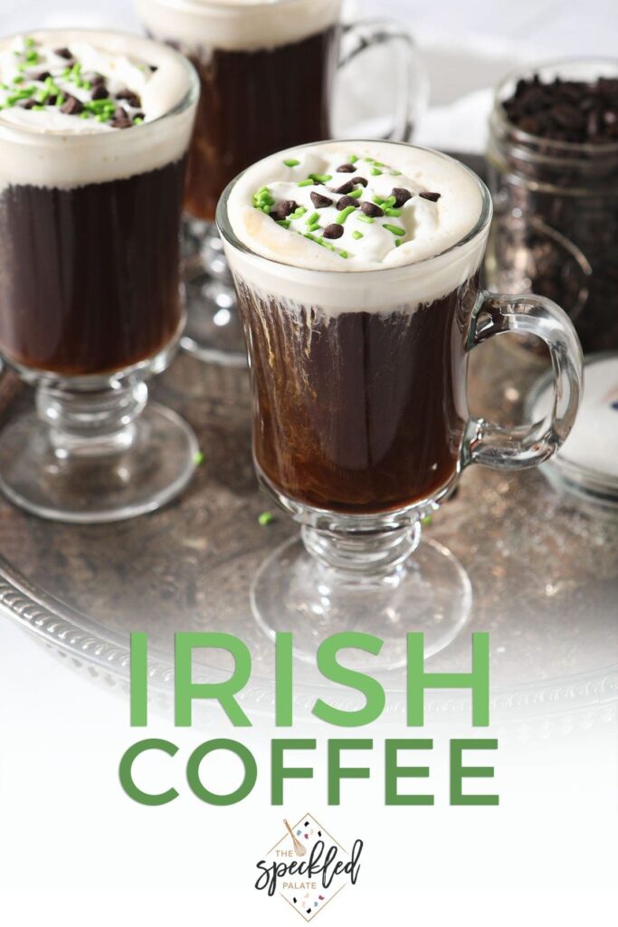 Three coffee cocktails with whipped cream, chocolate and green sprinkles on a silver tray with the text 'Irish coffee'