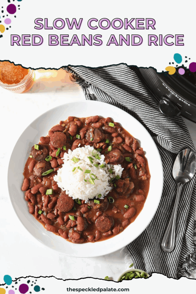 A bowl of Slow Cooker Red Beans and Rice sits next to a glass of beer and a slow cooker