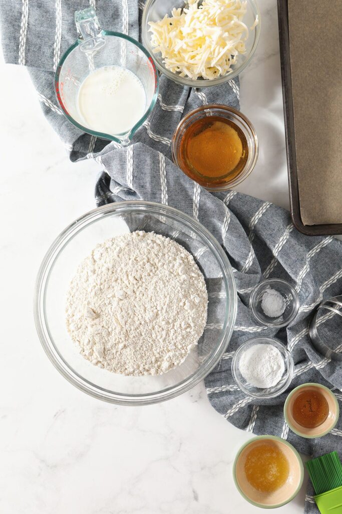 Homemade biscuit ingredients in bowls on marble