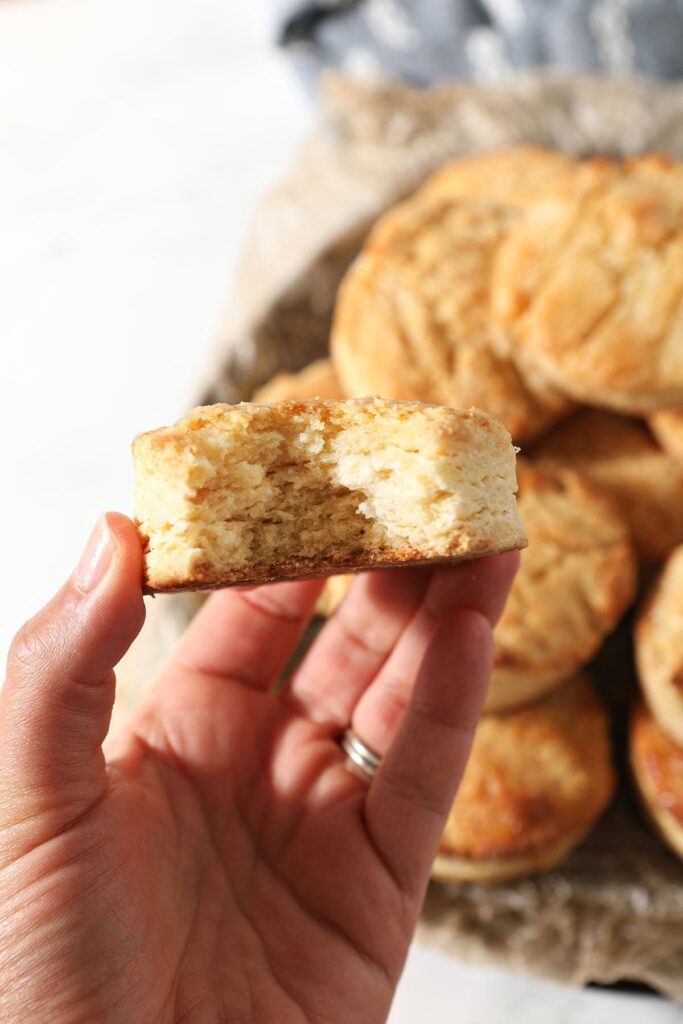 A hand holds a bitten-into honey butter biscuit