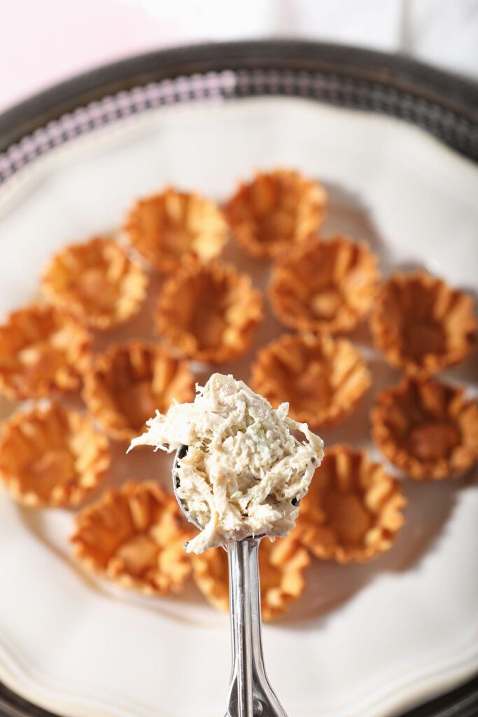 A scoop of chicken salad over a plate of phyllo shells