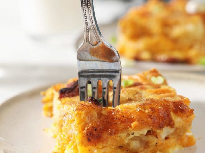 A fork cuts into a slice of breakfast tater tot casserole