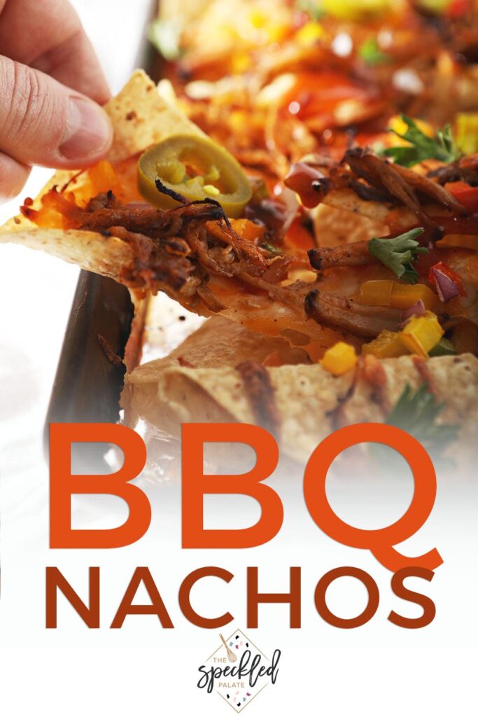 A person lifts a nacho from a tray with the text BBQ nachos