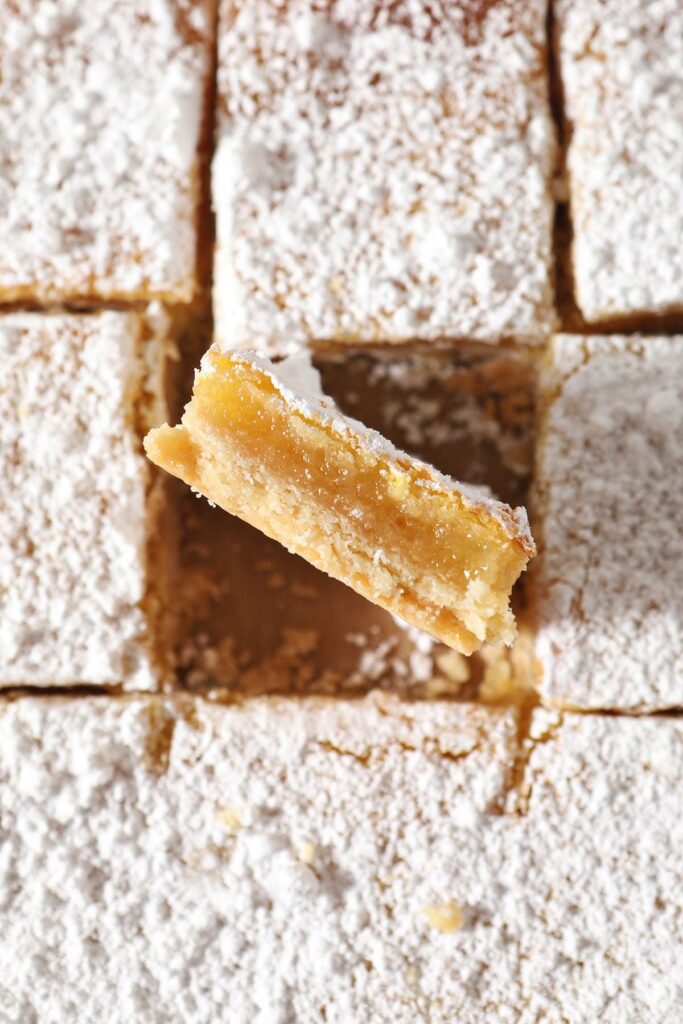 A lemon bar stands on its side next to other lemon bars