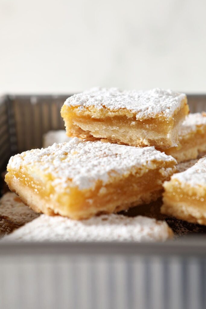 Stacked lemon bars in a metal pan