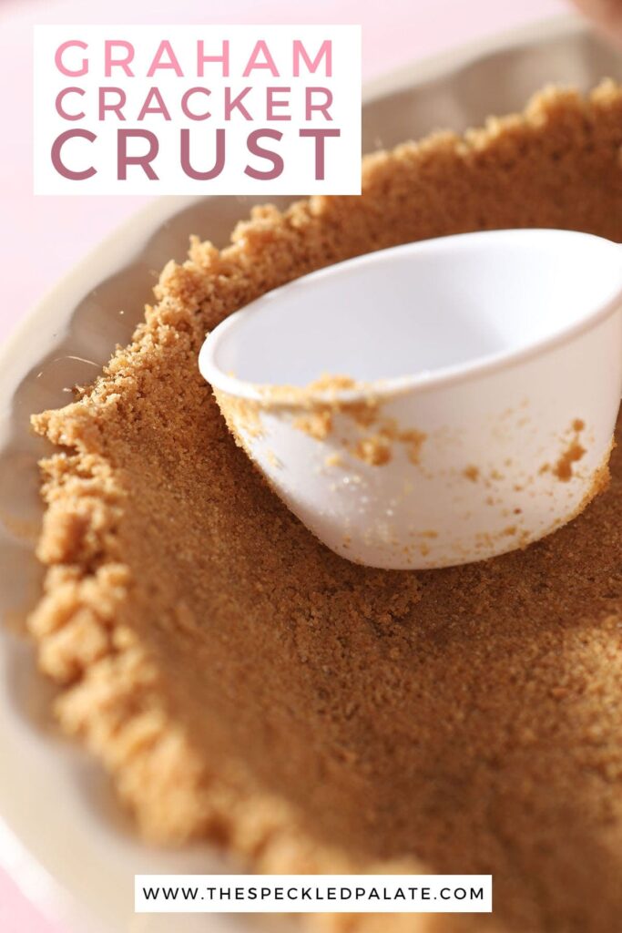 A white measuring scoop pushes graham cracker crumbs into place with the text graham cracker crust