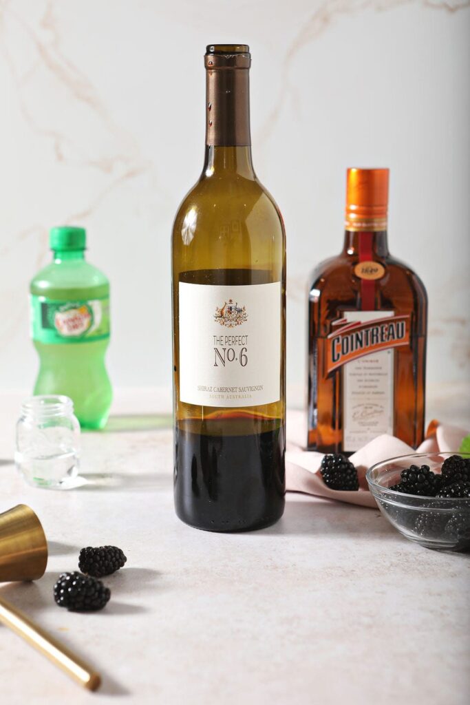 A bottle of wine with Cointreau and other drink ingredients