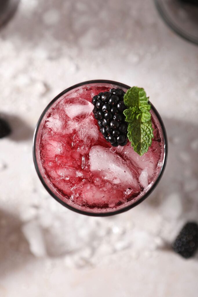 A blackberry drink garnished with blackberry and fresh mint