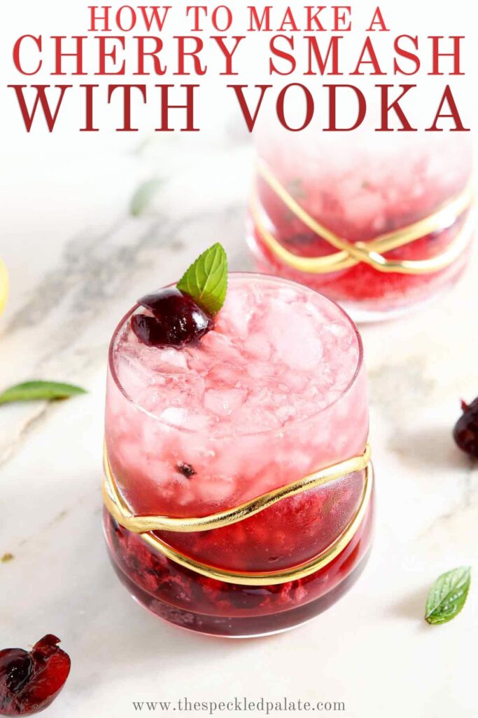 The Cherry Smash with Honeysuckle Vodka is a favorite summertime cocktail. Calling for just six ingredients, this cherry vodka drink is easy to mix at home and so refreshing. Switch it up and use bourbon, rum or plain vodka in place of the honeysuckle vodka! Makes 1 cherry drink. Two red drinks on marble with the text how to make a cherry smash with vodka