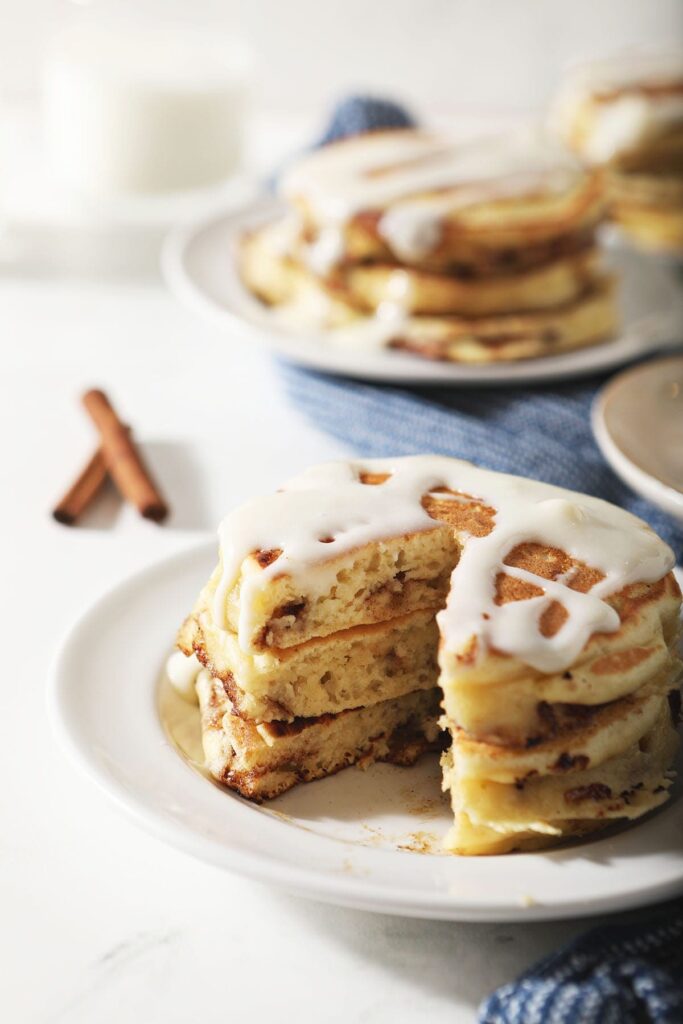 A sliced stack of pancakes with cream cheese glaze