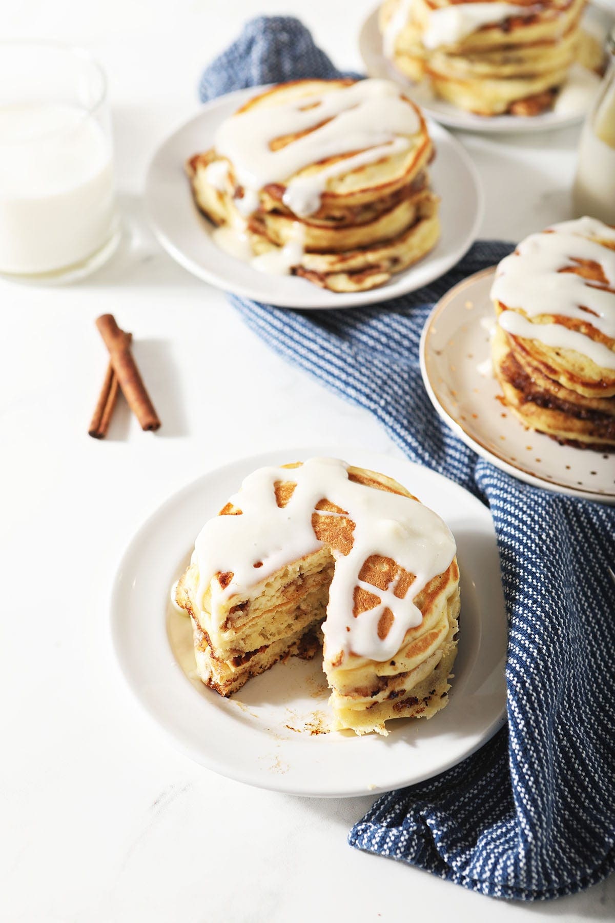 Three plates of pancakes with cream cheese glaze