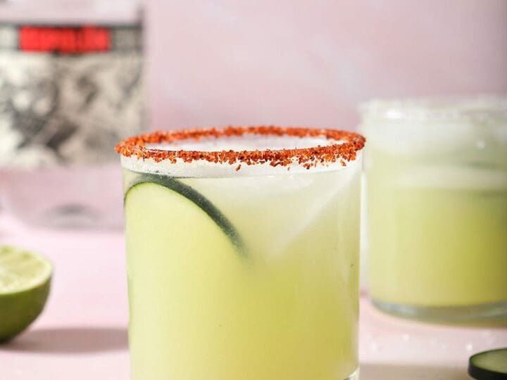 A cucumber margarita on a pink countertop