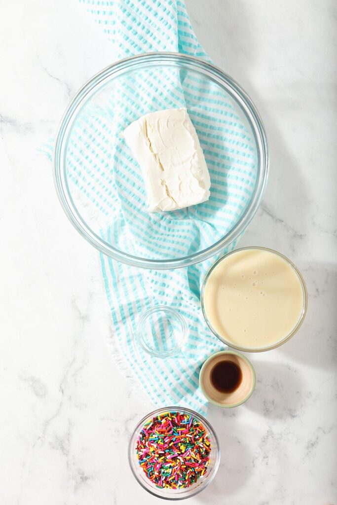 Ingredients for homemade Dunkaroos dip in bowls on marble