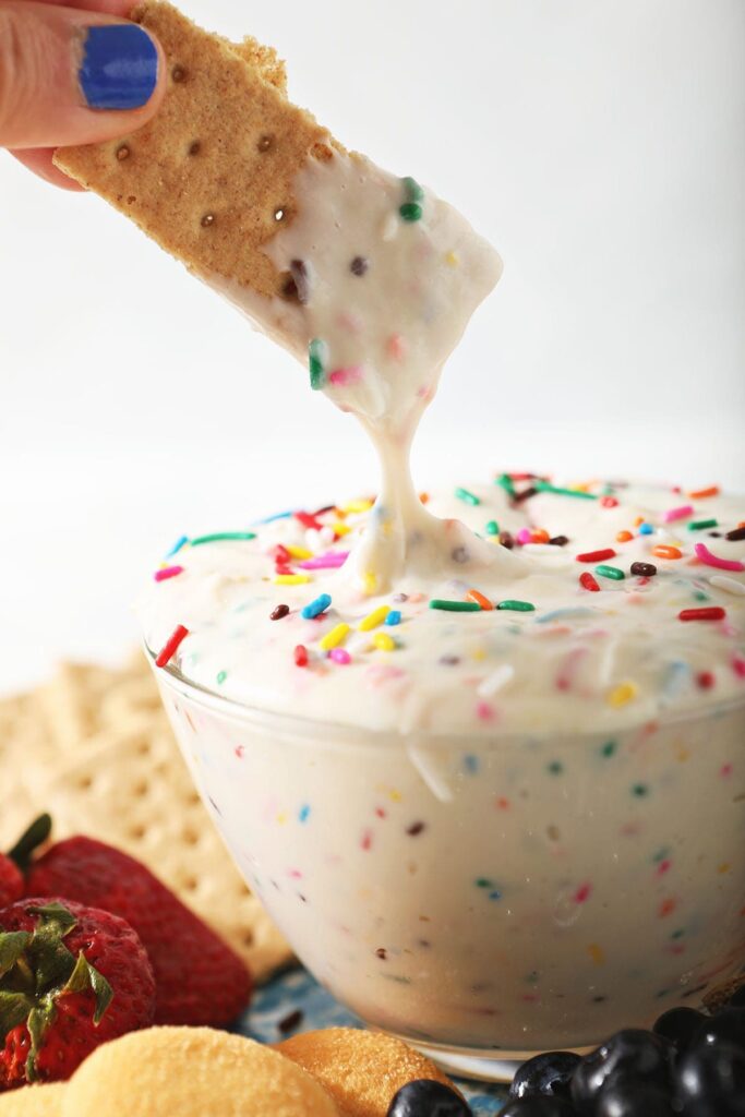 A graham cracker dips into Funfetti Dip