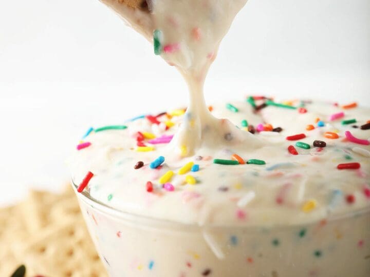 A graham cracker dips into Funfetti Dip