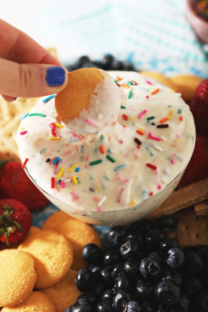 A wafer cookie dips into homemade Dunkaroos dip