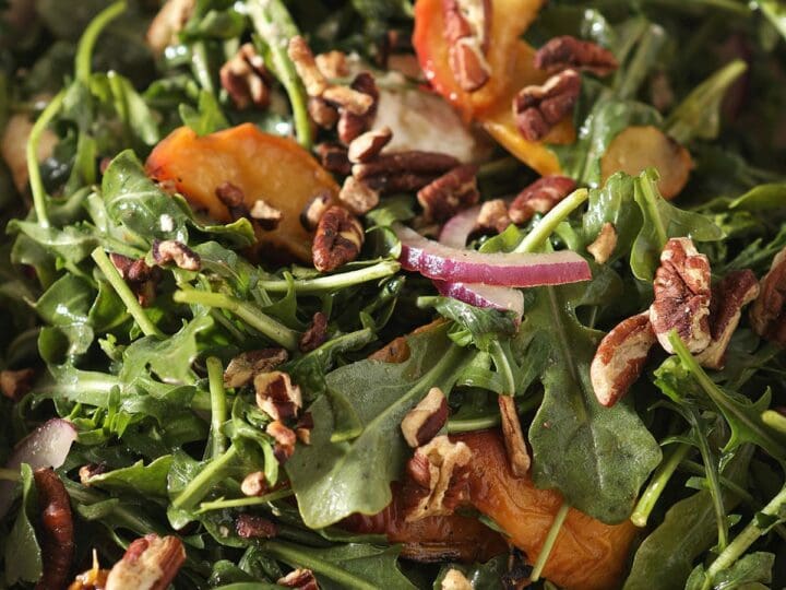 Close up of an arugula salad with peaches