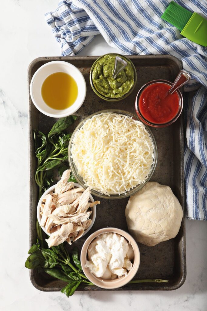 Ingredients for homemade pizza in bowls on a baking sheet