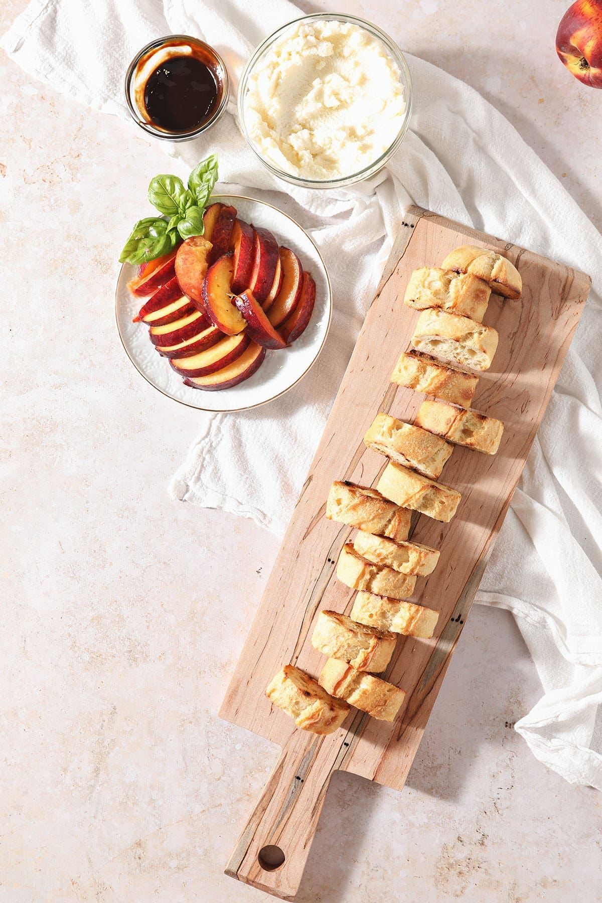 Ingredients to make crostini with peaches on boards and plates