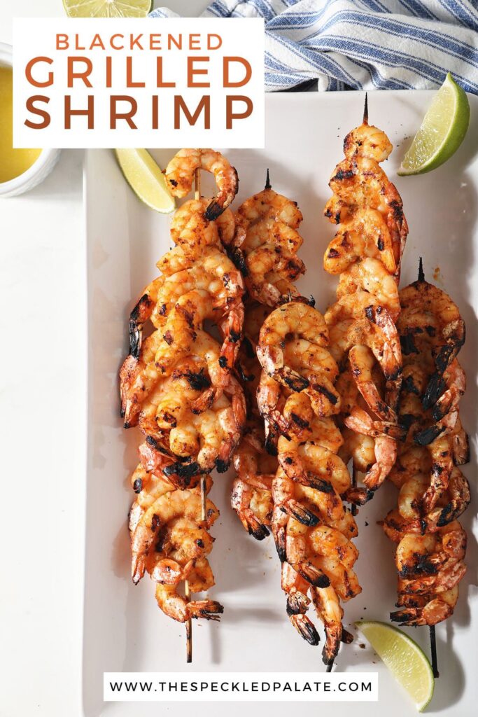 Grilled shrimp skewers on a white plate with lime wedges with the text blackened grilled shrimp