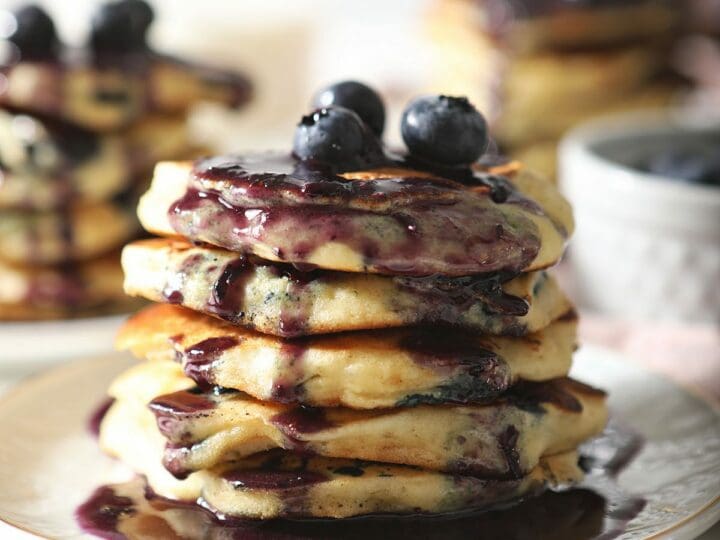 A stack of pancakes with blueberries and syrup
