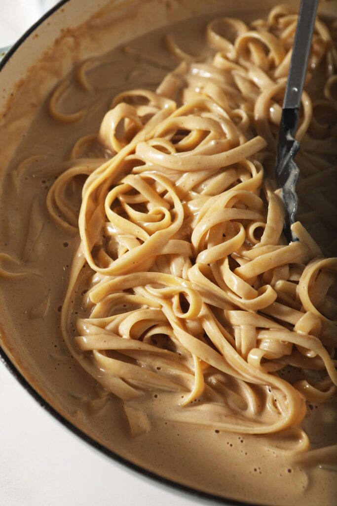 Noodles in cajun alfredo sauce in a saucepan