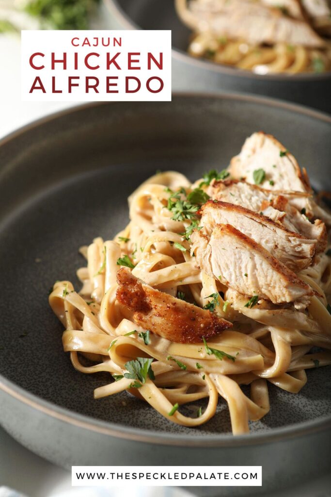 Close up of a bowl of pasta with chicken breast with the text cajun chicken alfredo