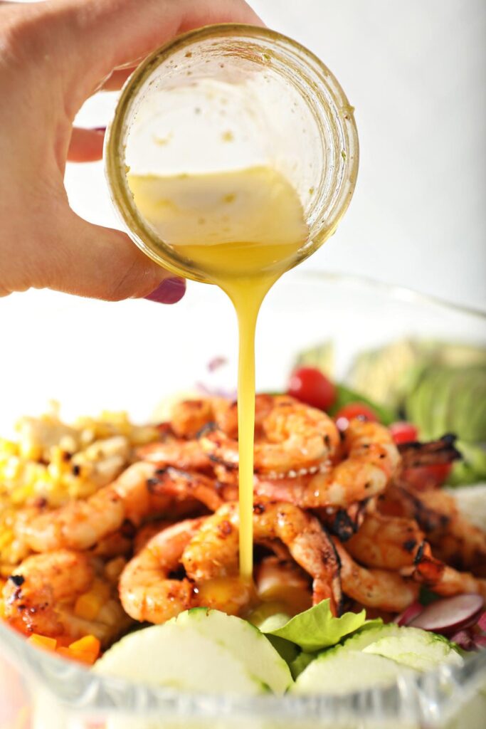 Lime vinaigrette pours on top of salad