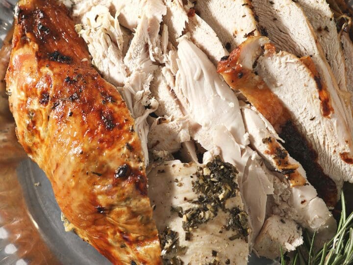 Sliced herb butter turkey breast on a silver tray