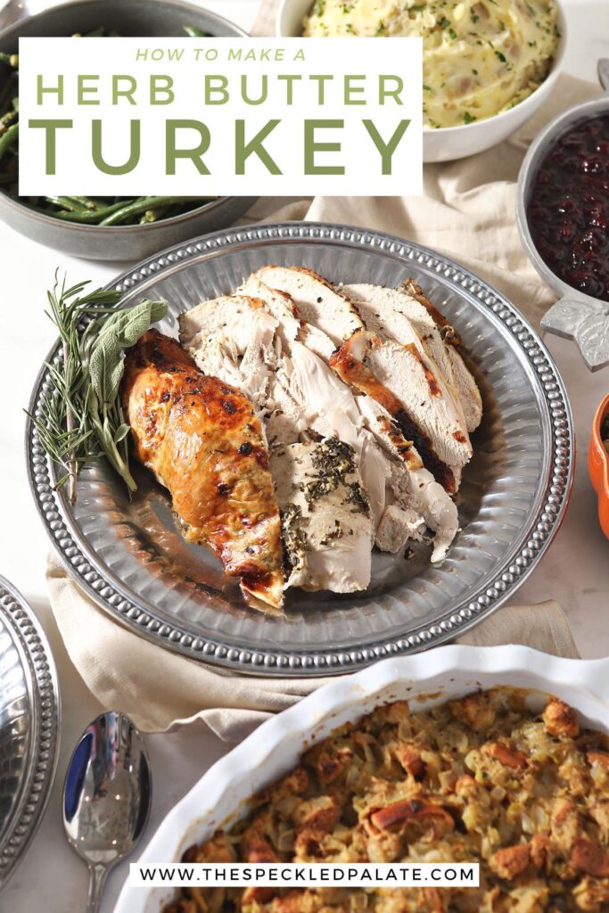 Sliced turkey on a silver platter with sides with the text how to make herb butter turkey