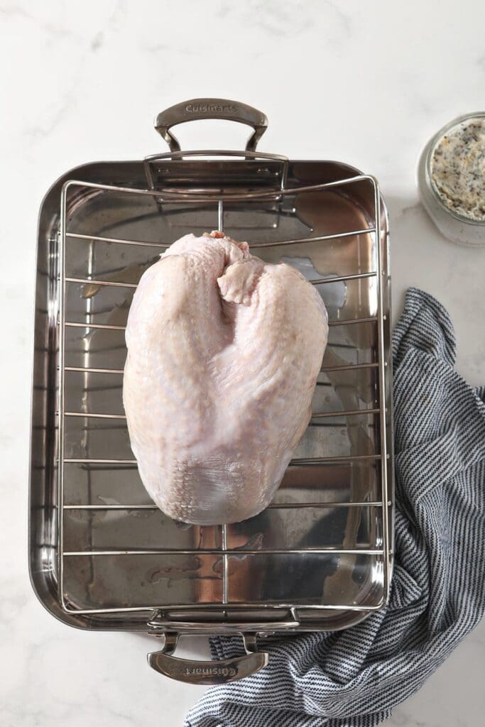 A turkey breast on a roasting pan before raosting