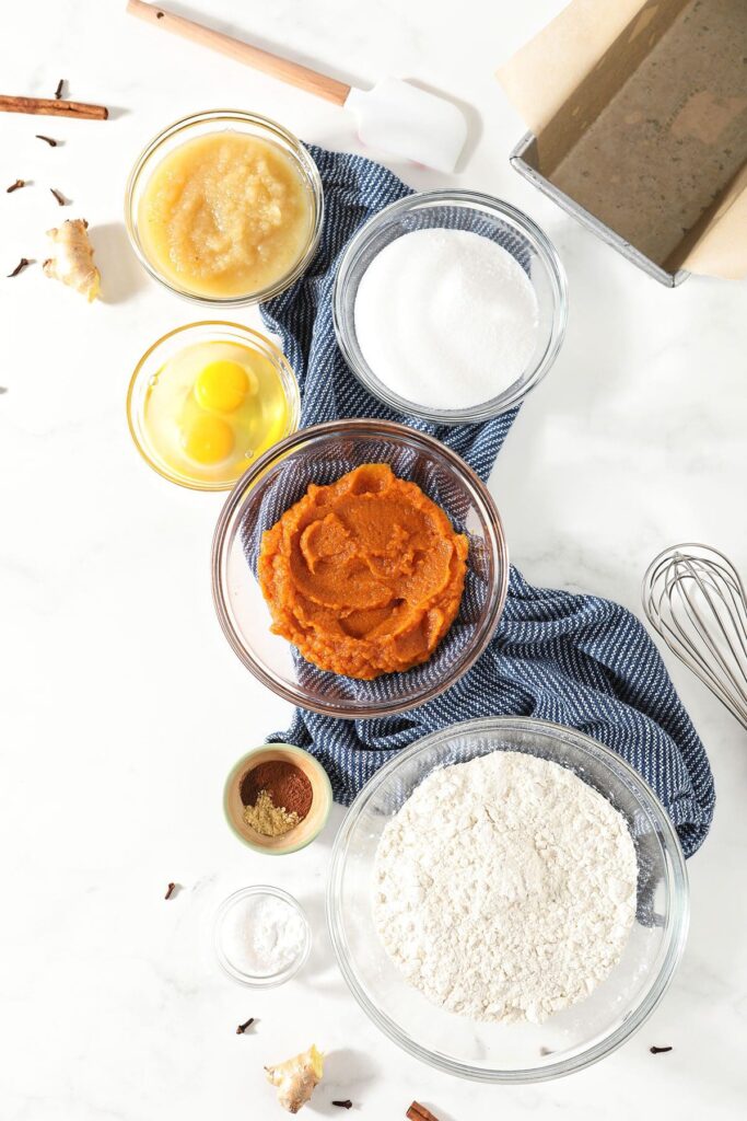 Pumpkin bread ingredients in bowls on marble