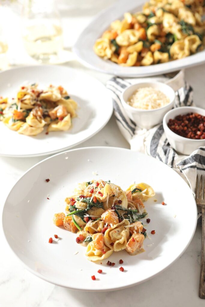 Three plates holding servings of creamy Tortellini Butternut Squash Pasta