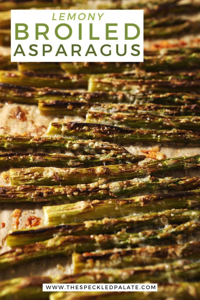 Cooked asparagus on a baking sheet with the text lemony broiled asparagus