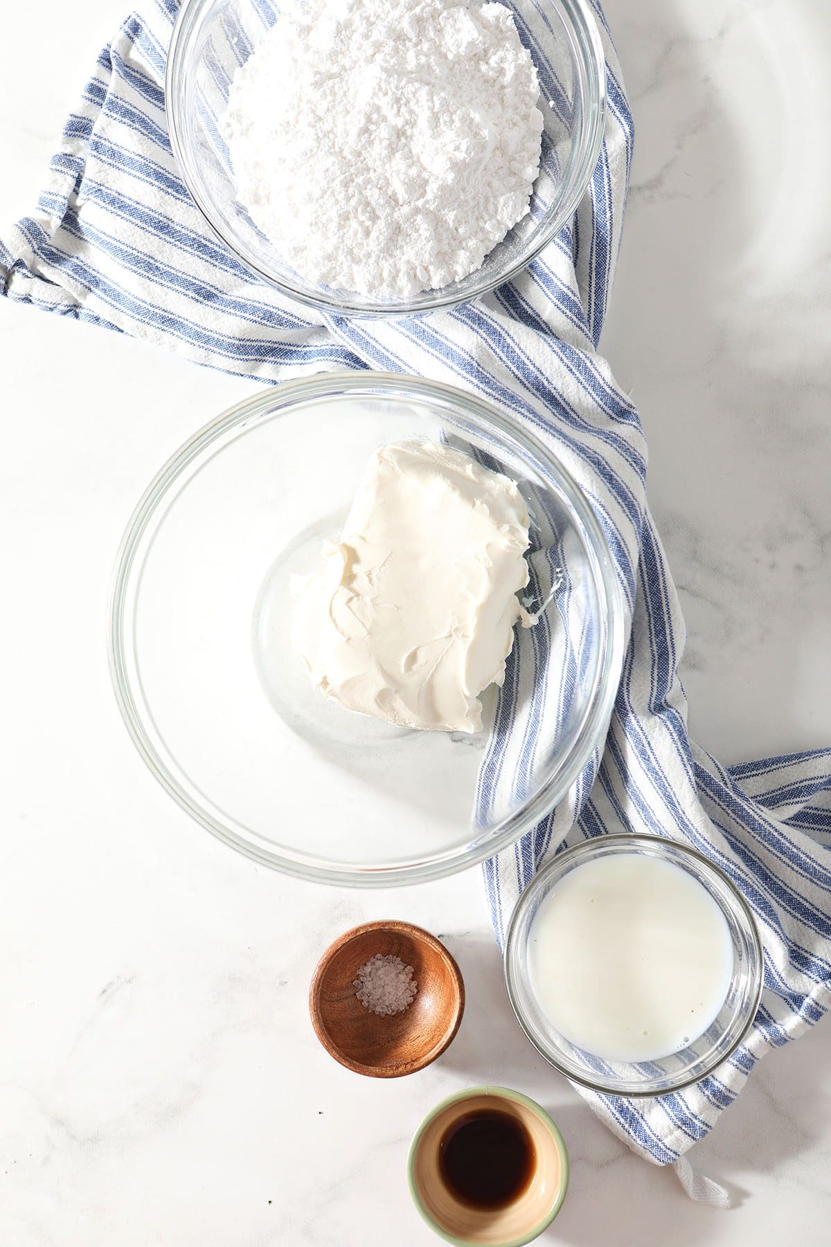 Ingredients for cheesecake dip in bowls on marble
