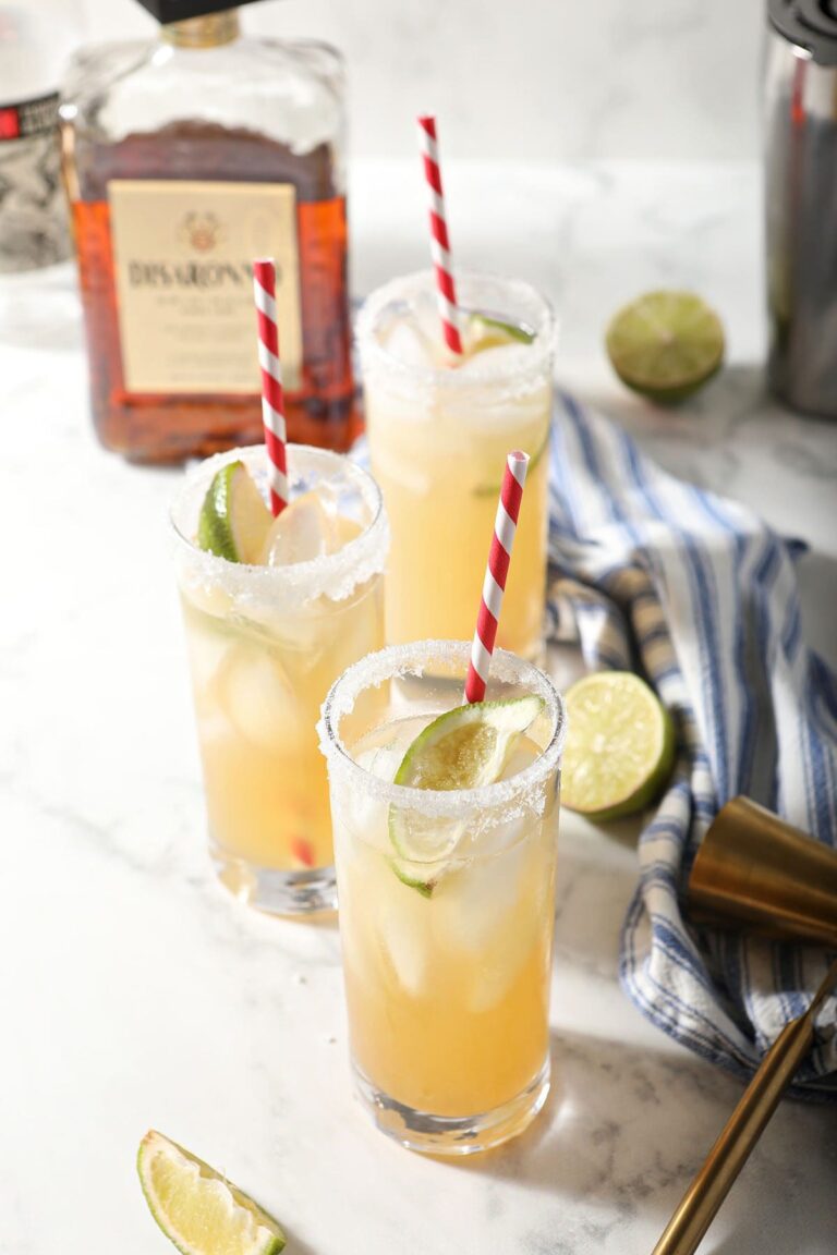 Three glasses holding Italian Margaritas with a bottle of amaretto