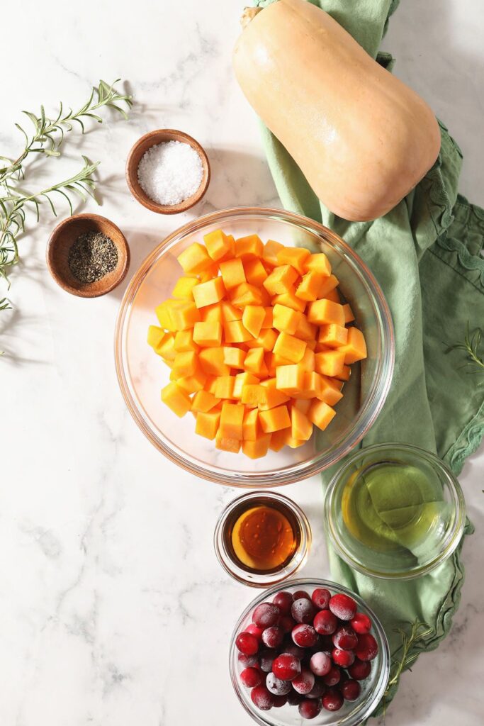 Butternut squash and other ingredients in bowls on marble