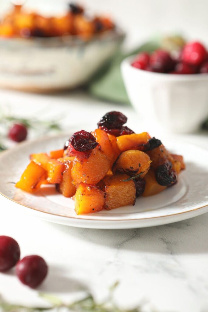 A white plate holds a serving of Maple Cranberry Roasted Butternut Squash