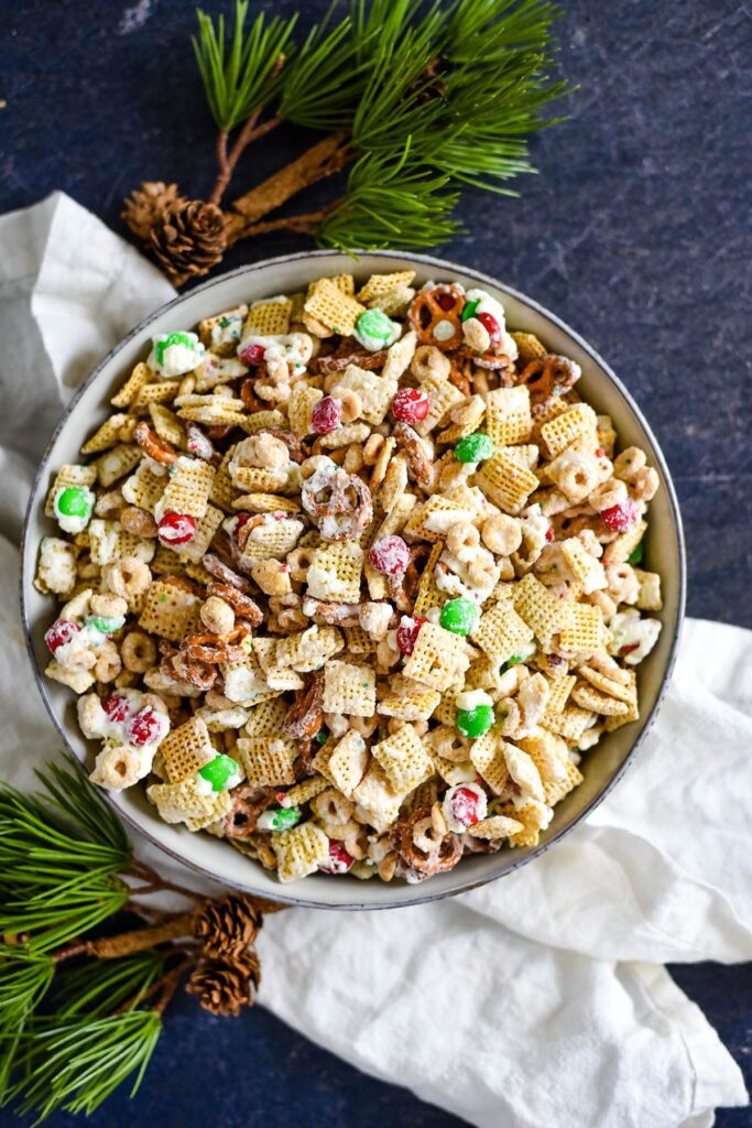 A bowl of Christmas Chex Mix with holly