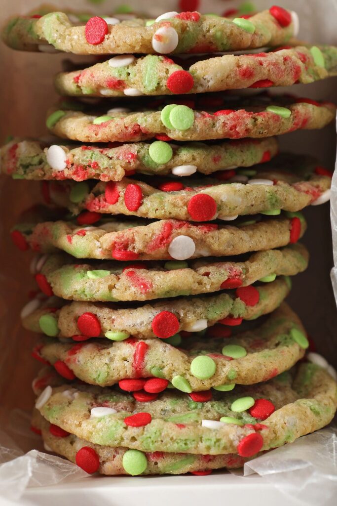 A stack of red and green sprinkle cookies in a box