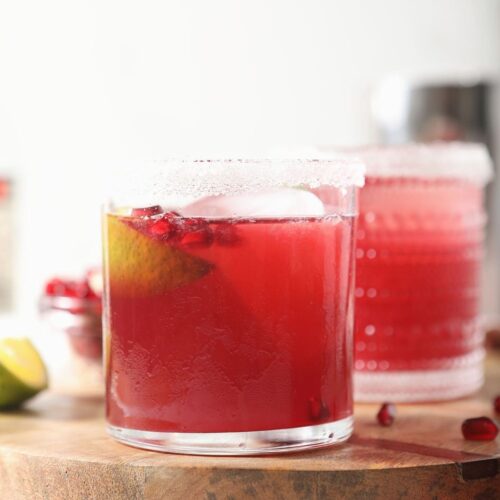 Two pink margaritas on a wooden board