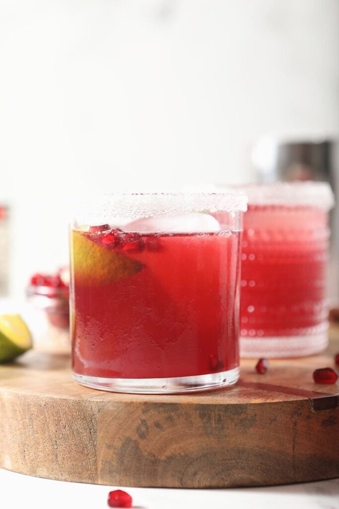 Two pink margaritas on a wooden board