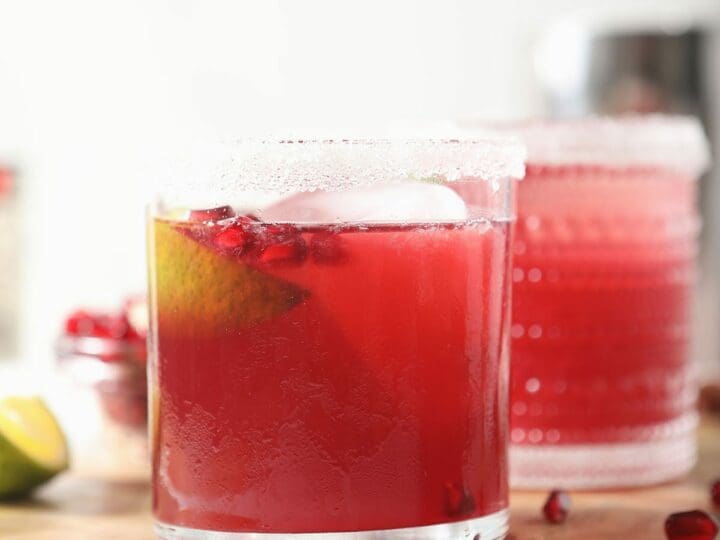 Two pink margaritas on a wooden board
