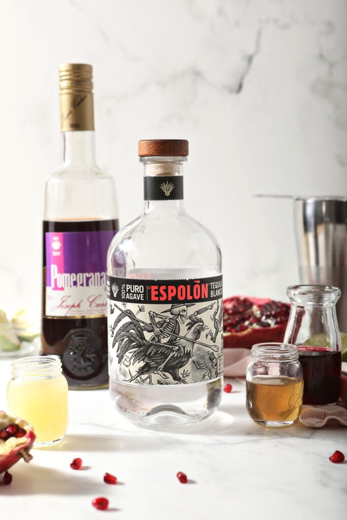 Tequila, pomegranate liqueur and other margarita ingredients on marble