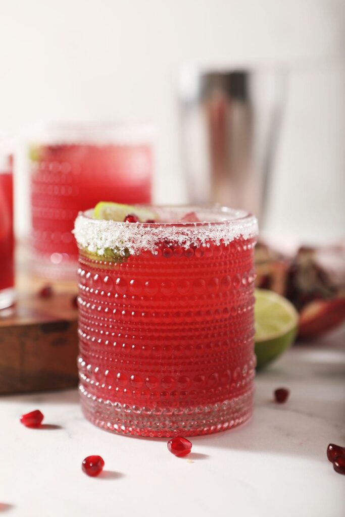  Three pomegranate margaritas with sugar rims on marble