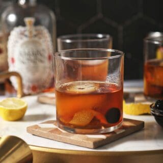 Three amaro cocktails on wooden trivets with lemons