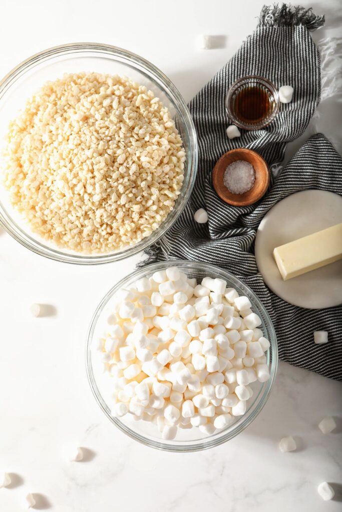 Bowls holding crispy rice treat ingredients on marble