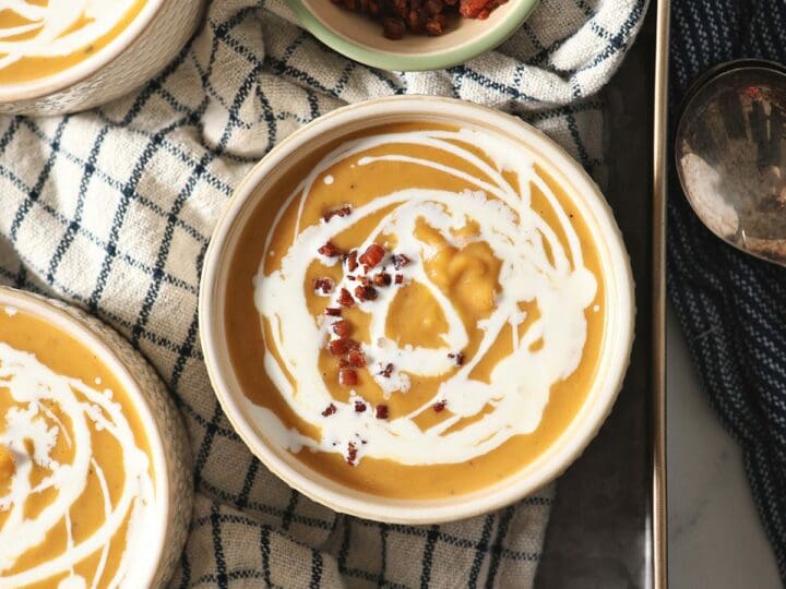 Four bowls of Roasted Butternut Squash Soup on a blue striped towel